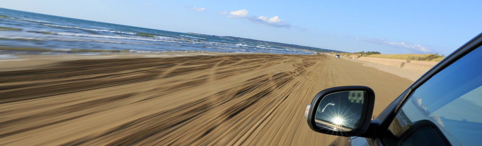 千里浜なぎさドライブウェイを走る車から見た砂浜と海